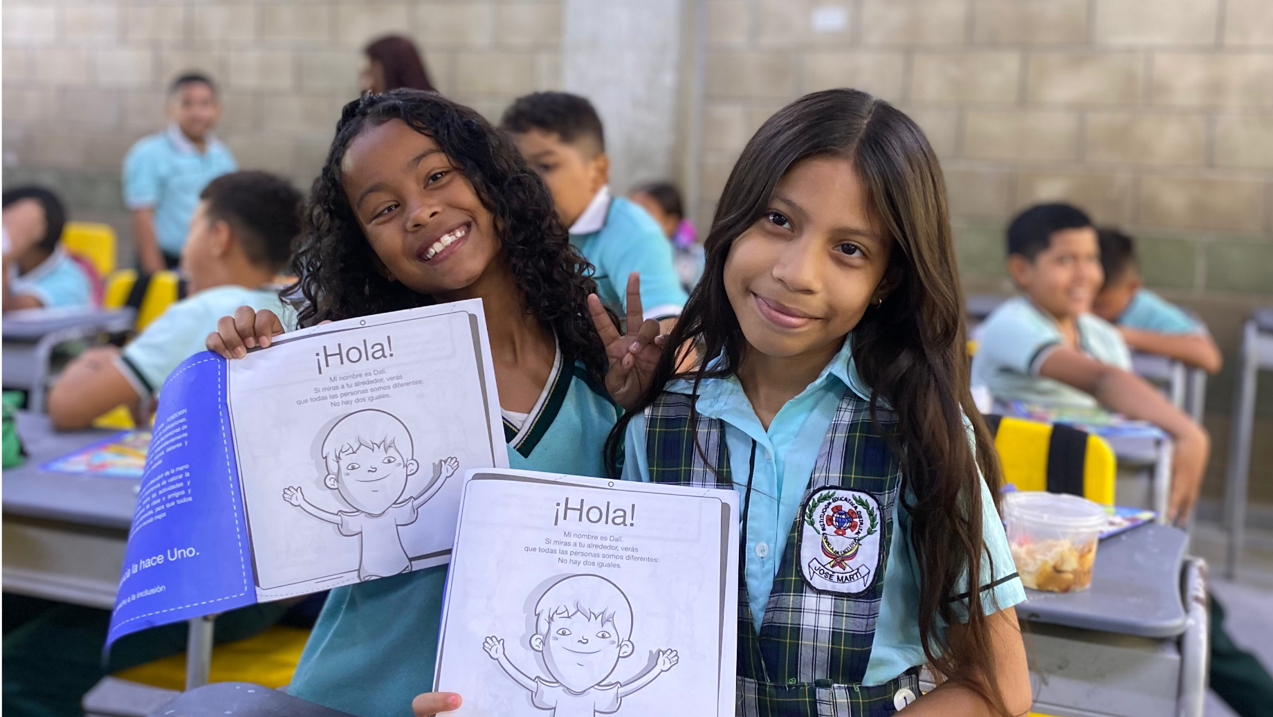 Niñas escolares mostrando sus cartillas